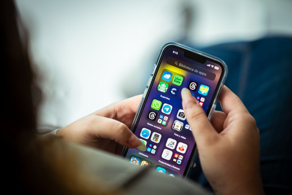Creador de contenido usando una app de diseño gráfico en su teléfono móvil.