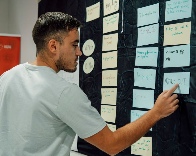 Persona trabajando creativamente con ayuda de inteligencia artificial y prompts en un entorno de oficina moderno