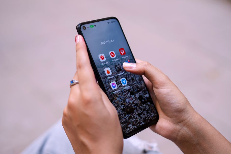 Persona analizando diferentes herramientas digitales para programación de contenido en redes sociales.